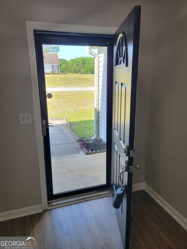 foyer entrance featuring baseboards and wood finished floors