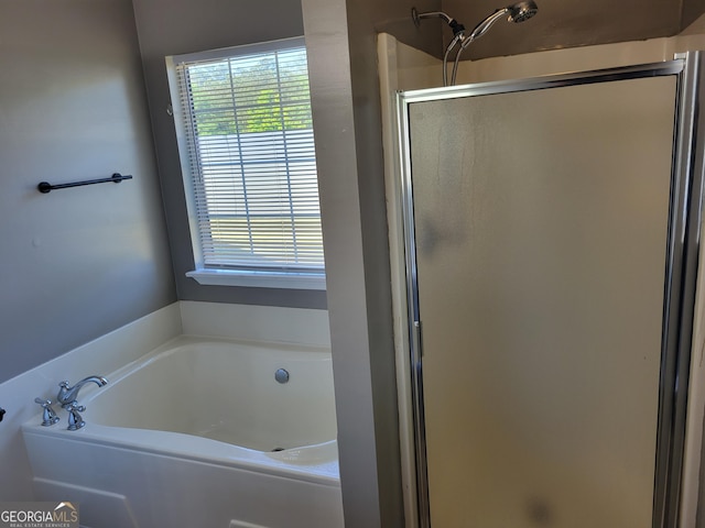 bathroom with a stall shower, a garden tub, and a wealth of natural light