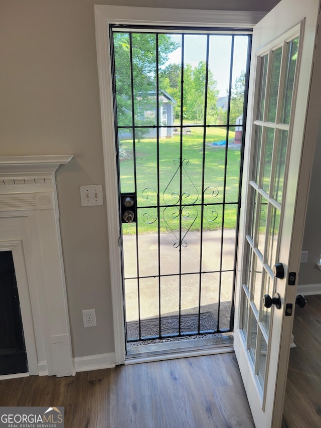 doorway to outside featuring baseboards and wood finished floors