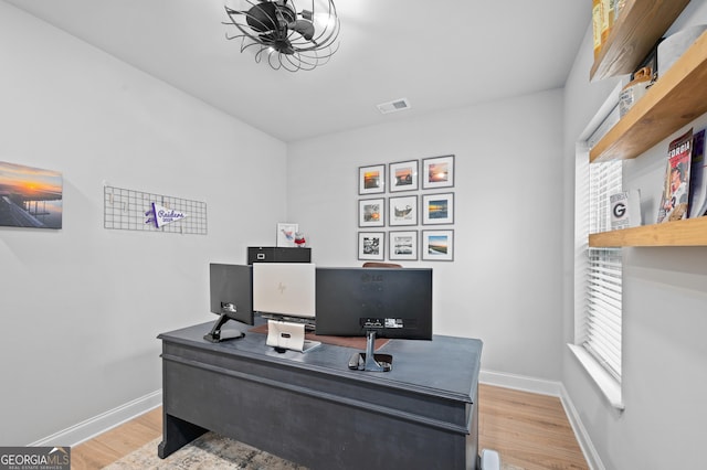 office area featuring light wood-type flooring, visible vents, and baseboards