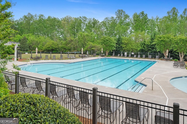 pool with a patio and fence