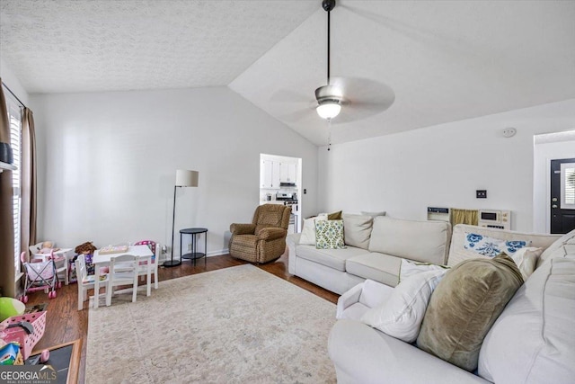 living area with a ceiling fan, wood finished floors, and lofted ceiling
