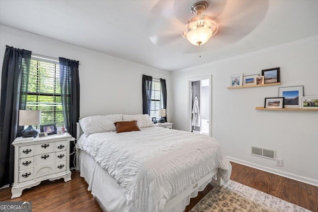bedroom with a ceiling fan, visible vents, dark wood finished floors, baseboards, and ornamental molding