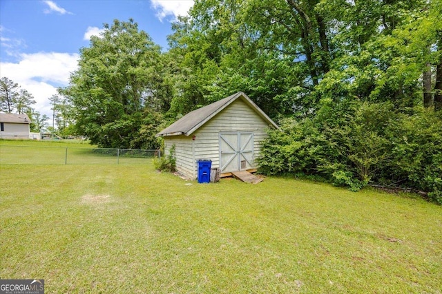 view of yard featuring fence, an outbuilding, and a storage unit