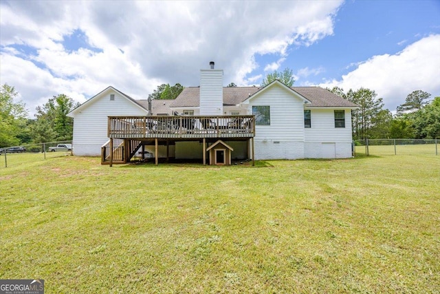 rear view of house with a fenced backyard, a yard, a wooden deck, and stairs
