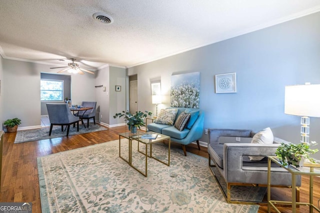 520 Park Ave SE Unit 10, Atlanta, GA 30312 - living room with crown molding, ceiling fan, a textured ceiling, wood finished floors, and visible vents