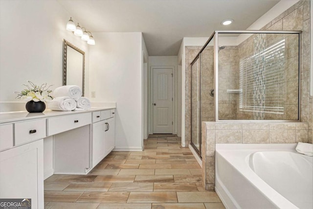 308 Evening Rain Crst, Canton, GA 30114 - bathroom featuring vanity, a bath, a stall shower, wood tiled floors, and recessed lighting
