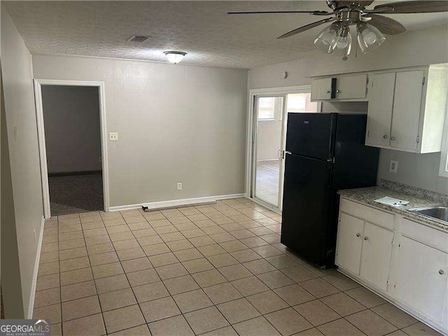 8922 Gatewood Cir, Jonesboro, GA 30238 - kitchen with light tile patterned floors, ceiling fan, freestanding refrigerator, and a textured ceiling