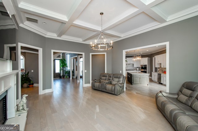 living area with crown molding, baseboards, an inviting chandelier, and coffered ceiling