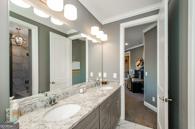 ensuite bathroom featuring double vanity, ornamental molding, a sink, and marble finish floor