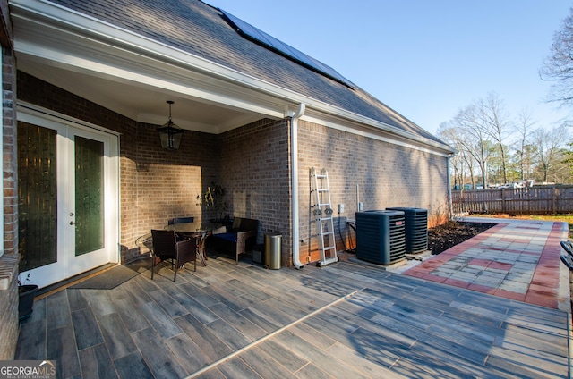 wooden deck featuring french doors, central air condition unit, fence, and outdoor dining space