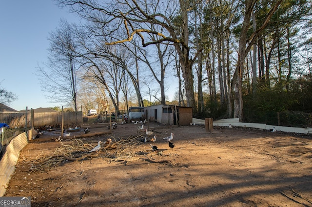 view of yard with fence and an outbuilding