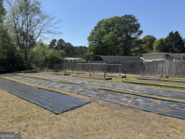 view of swimming pool featuring fence and a garden