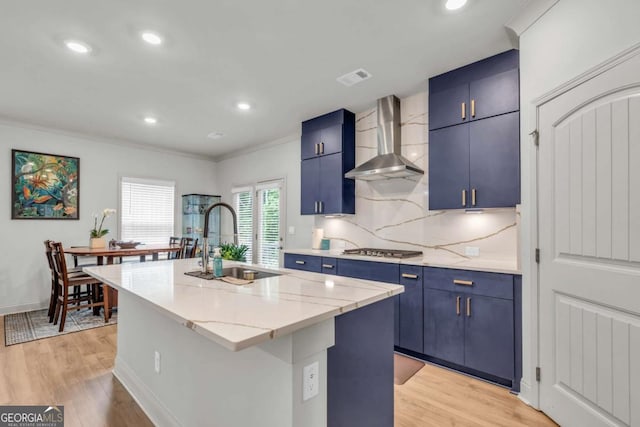 3493 Monarch Ave, Duluth, GA 30096 - kitchen featuring a sink, stainless steel gas stovetop, wall chimney range hood, and blue cabinetry