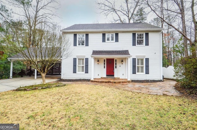 colonial-style house featuring a front lawn, board and batten siding, fence, and concrete driveway