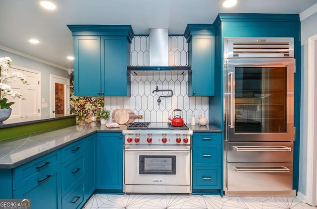 kitchen featuring decorative backsplash, fridge, a peninsula, designer range, and wall chimney exhaust hood