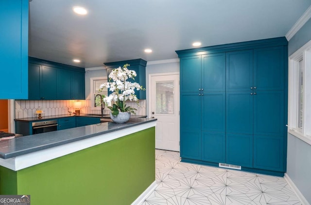 kitchen with recessed lighting, dark countertops, ornamental molding, and a sink