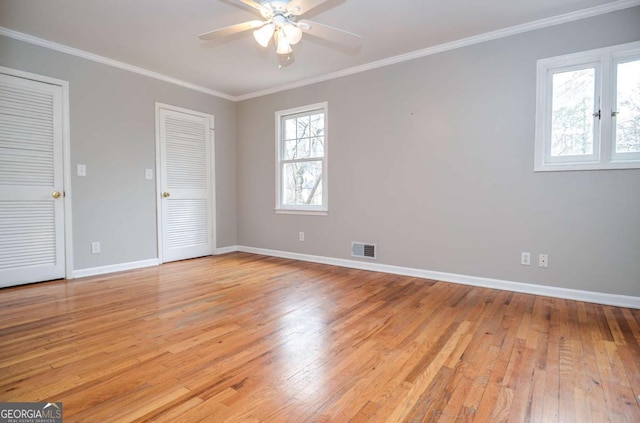 unfurnished bedroom with crown molding, baseboards, light wood-style flooring, and visible vents