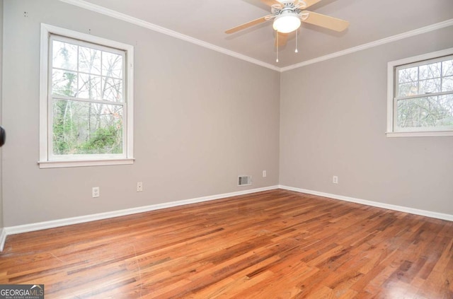 unfurnished room with visible vents, baseboards, plenty of natural light, and wood finished floors