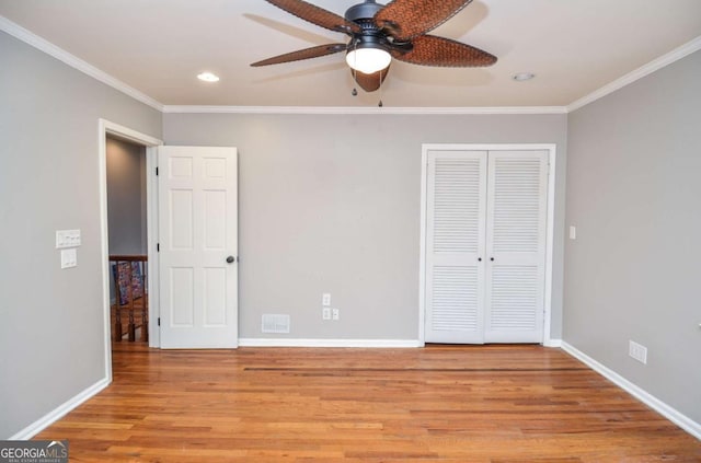 unfurnished bedroom featuring a closet, ornamental molding, wood finished floors, baseboards, and recessed lighting