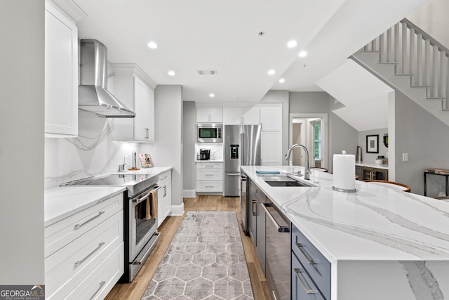 1010F Tailwater, Greensboro, GA 30642 - kitchen featuring visible vents, a spacious island, a sink, stainless steel appliances, and wall chimney exhaust hood