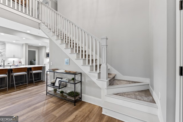 1010F Tailwater, Greensboro, GA 30642 - staircase featuring baseboards, wood finished floors, and a high ceiling