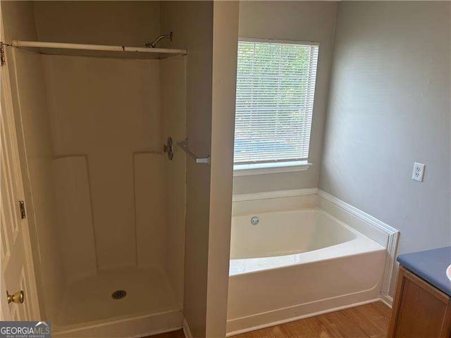 full bathroom featuring a garden tub, vanity, wood finished floors, and a shower stall