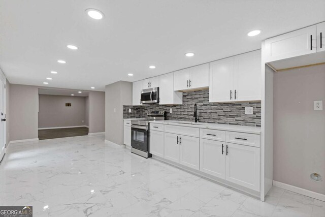 470 Brackin Trce, Grayson, GA 30017 - kitchen with appliances with stainless steel finishes, a sink, light countertops, marble finish floor, and baseboards