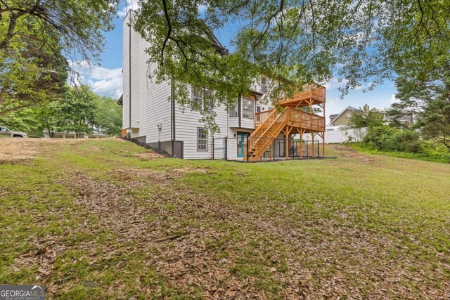 470 Brackin Trce, Grayson, GA 30017 - back of property with a wooden deck, stairs, a chimney, and a lawn