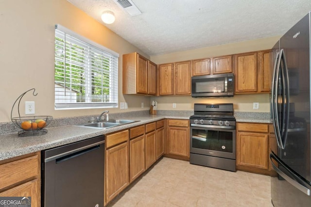 171 Nacoochee Way, Canton, GA 30114 - kitchen with stainless steel appliances, a sink, brown cabinets, a textured ceiling, and light countertops