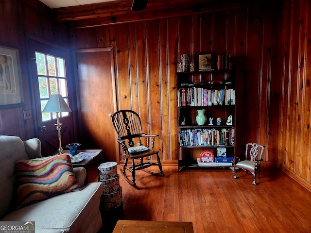 living area featuring wood walls and wood finished floors