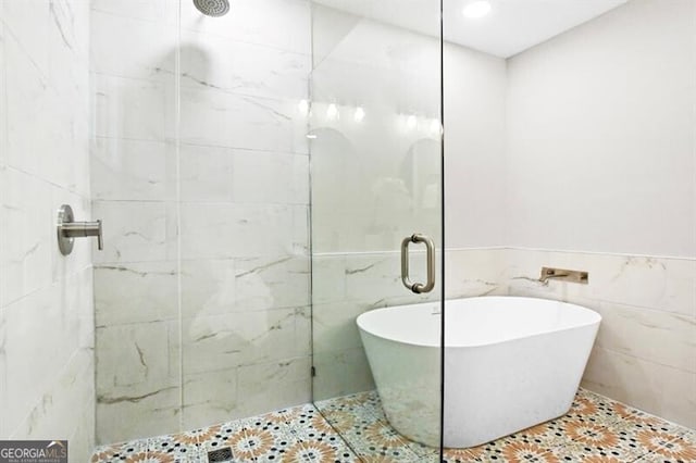 1140 Starline Dr SE, Smyrna, GA 30080 - full bathroom with tile patterned floors, a freestanding bath, a tile shower, and tile walls