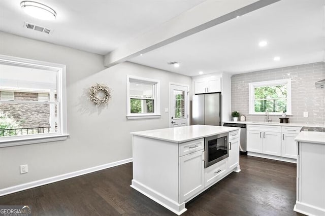 1140 Starline Dr SE, Smyrna, GA 30080 - kitchen with backsplash, stainless steel appliances, white cabinetry, and a sink