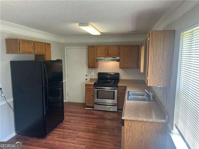 5340 Forest Pl, Stone Mountain, GA 30088 - kitchen featuring freestanding refrigerator, gas stove, under cabinet range hood, brown cabinets, and a textured ceiling