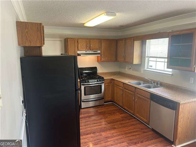 5340 Forest Pl, Stone Mountain, GA 30088 - kitchen featuring stainless steel appliances, under cabinet range hood, ornamental molding, brown cabinets, and a textured ceiling