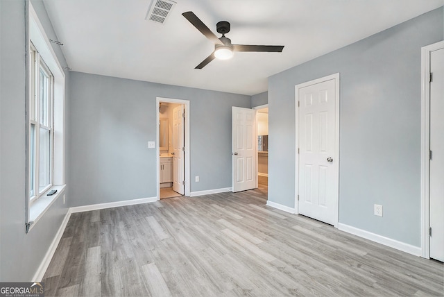 unfurnished bedroom featuring baseboards, wood finished floors, and visible vents