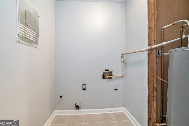 washroom featuring laundry area, tile patterned flooring, baseboards, electric dryer hookup, and water heater