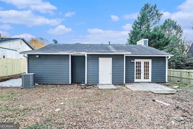 rear view of property with central AC, a fenced backyard, a chimney, french doors, and a patio
