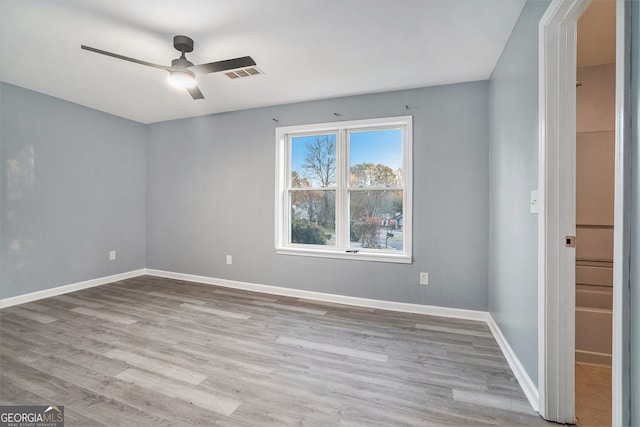 unfurnished room featuring visible vents, baseboards, ceiling fan, and wood finished floors