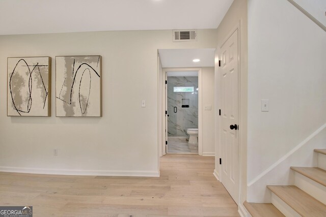 corridor with stairs, recessed lighting, baseboards, light wood-type flooring, and visible vents