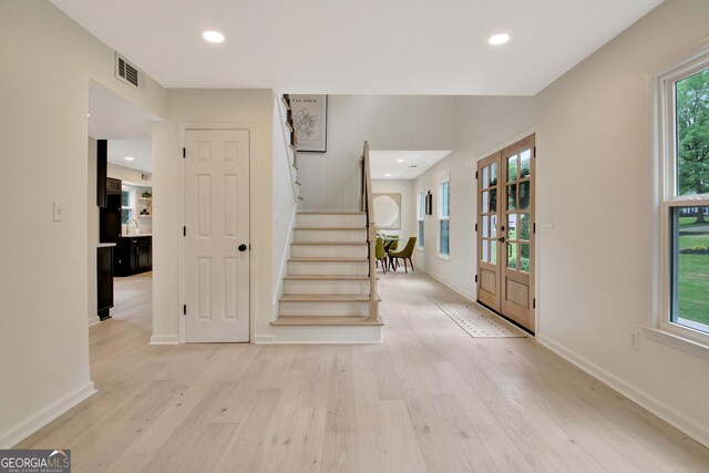 foyer entrance featuring visible vents, stairs, light wood-style floors, baseboards, and recessed lighting