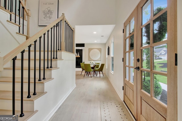 interior space featuring stairway, baseboards, plenty of natural light, and light wood-style flooring