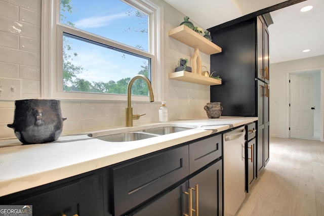 kitchen with open shelves, decorative backsplash, a sink, light wood finished floors, and dishwasher