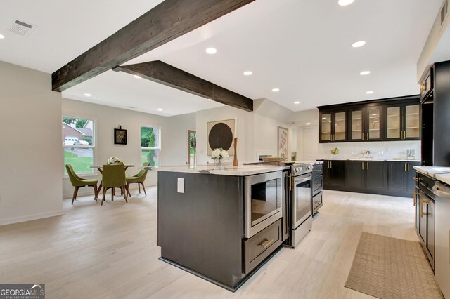 kitchen with visible vents, a center island, stainless steel range with electric stovetop, light wood-style floors, and recessed lighting