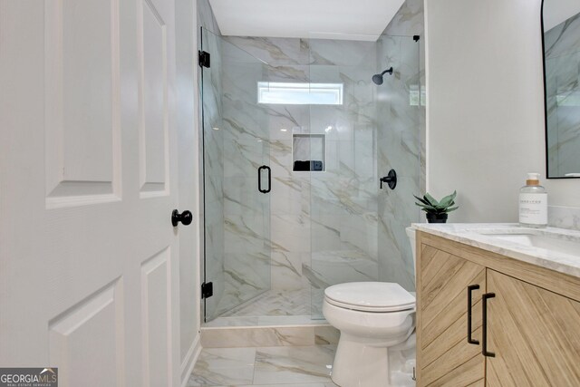 bathroom with a marble finish shower, vanity, toilet, and marble finish floor
