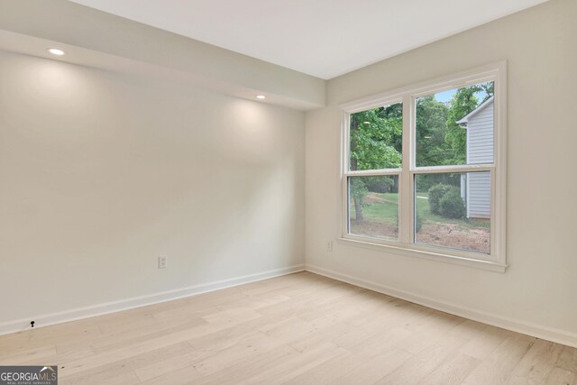 spare room featuring light wood-style floors, recessed lighting, and baseboards
