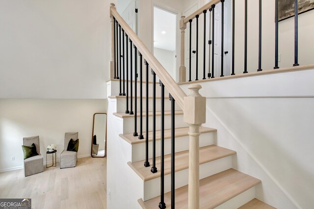 staircase featuring baseboards and wood finished floors