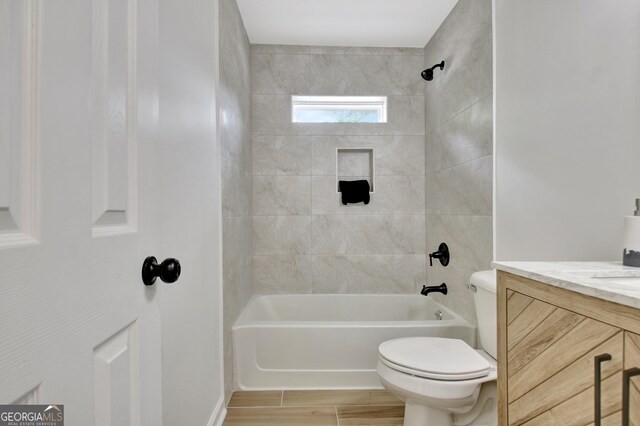 bathroom featuring vanity, washtub / shower combination, wood finished floors, and toilet