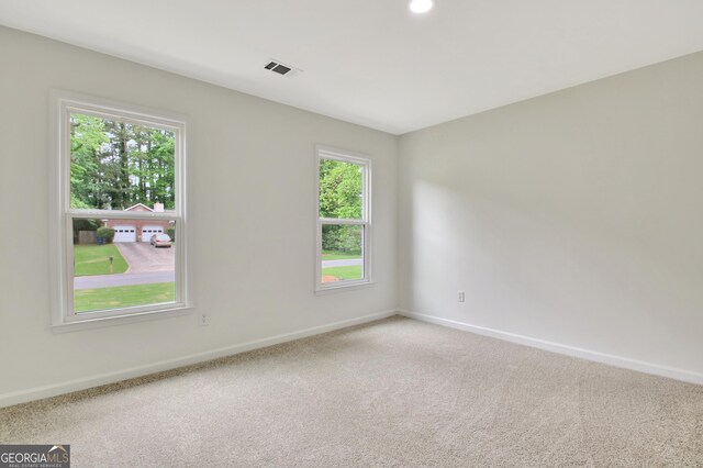 spare room featuring baseboards, carpet floors, and visible vents