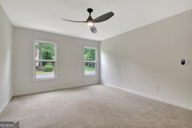 carpeted empty room with baseboards and ceiling fan